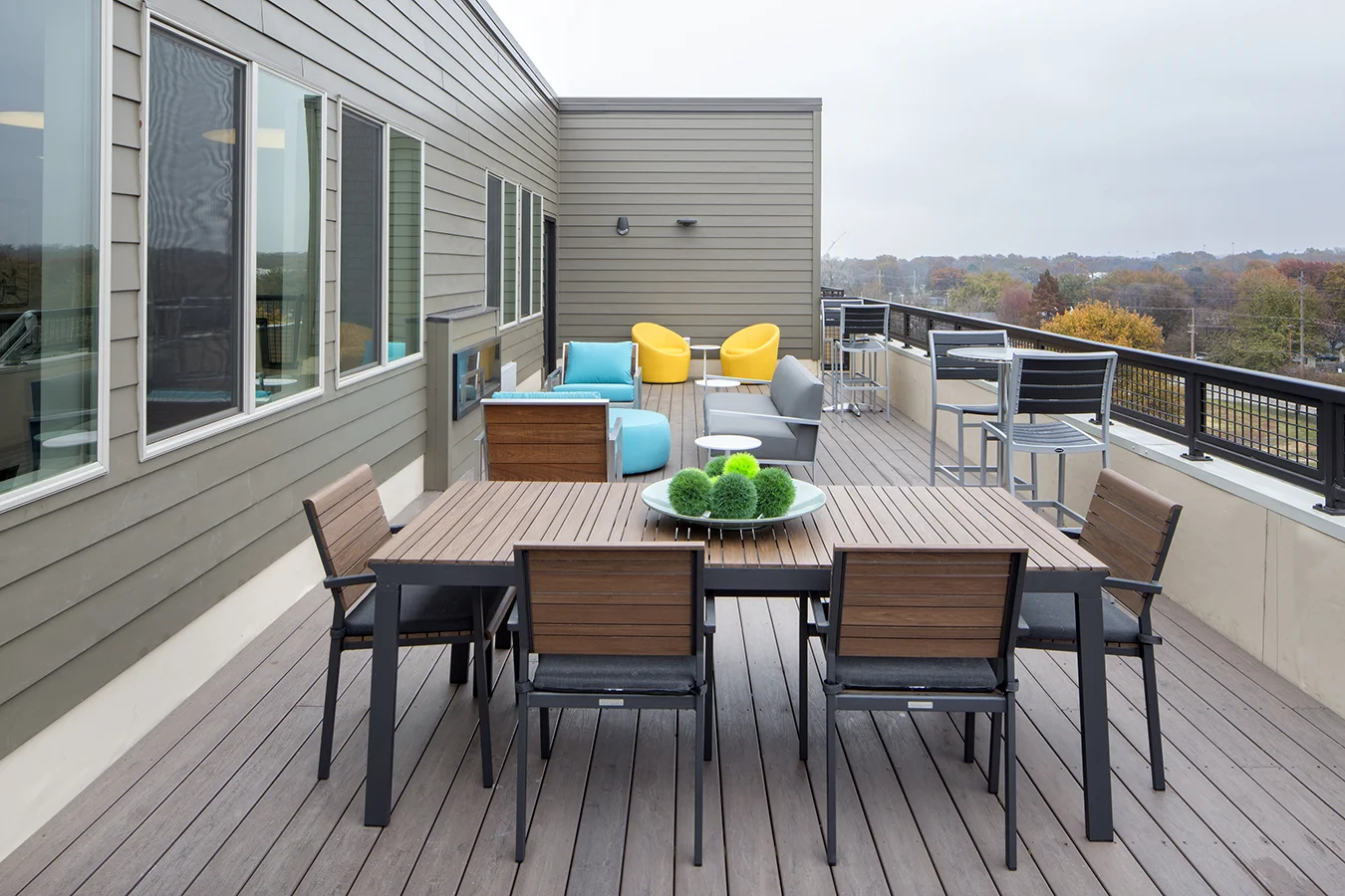 Rooftop deck with an outdoor dining table and yellow lounge chairs