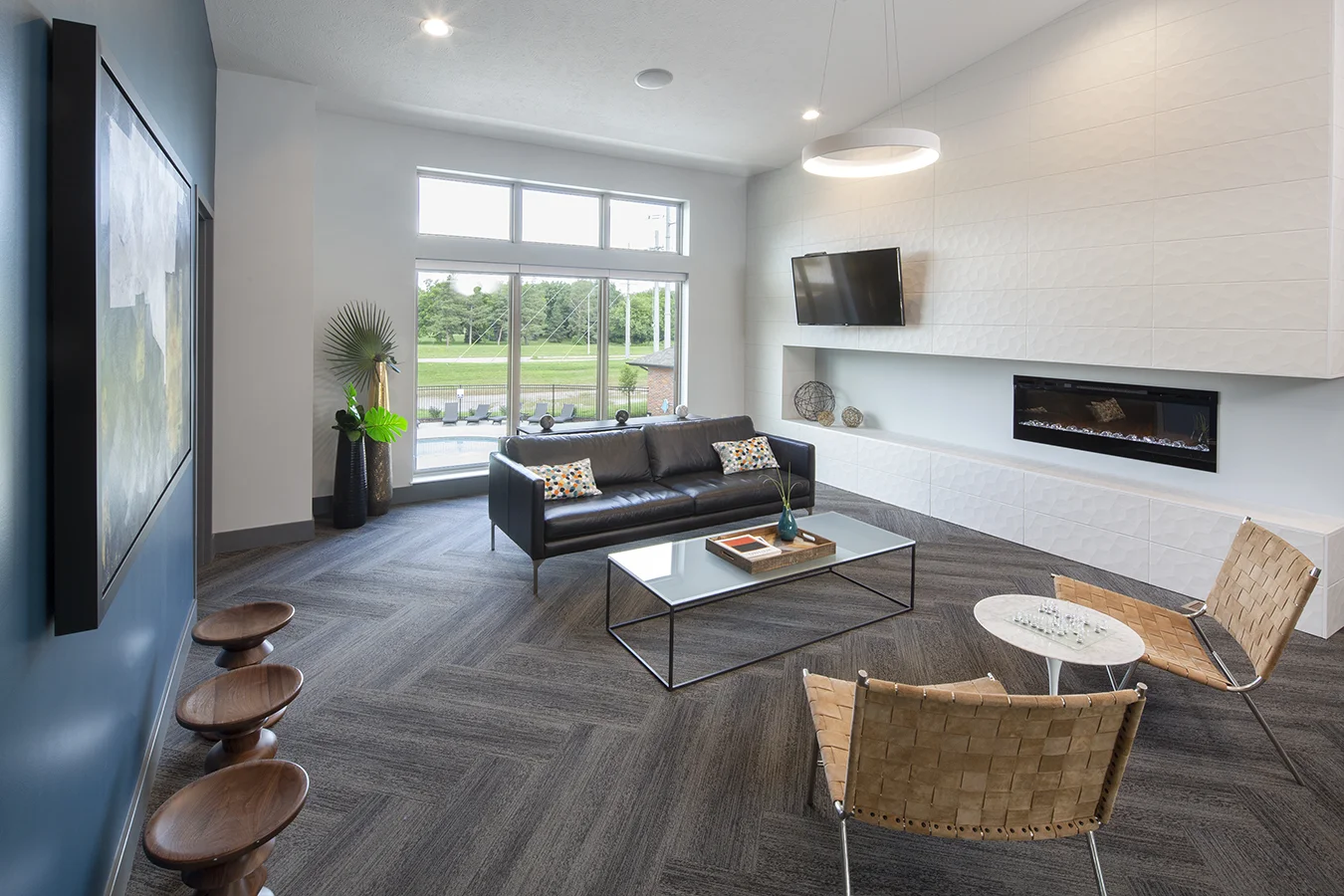 Lounge with a linear fireplace, black leather sofa and large windows