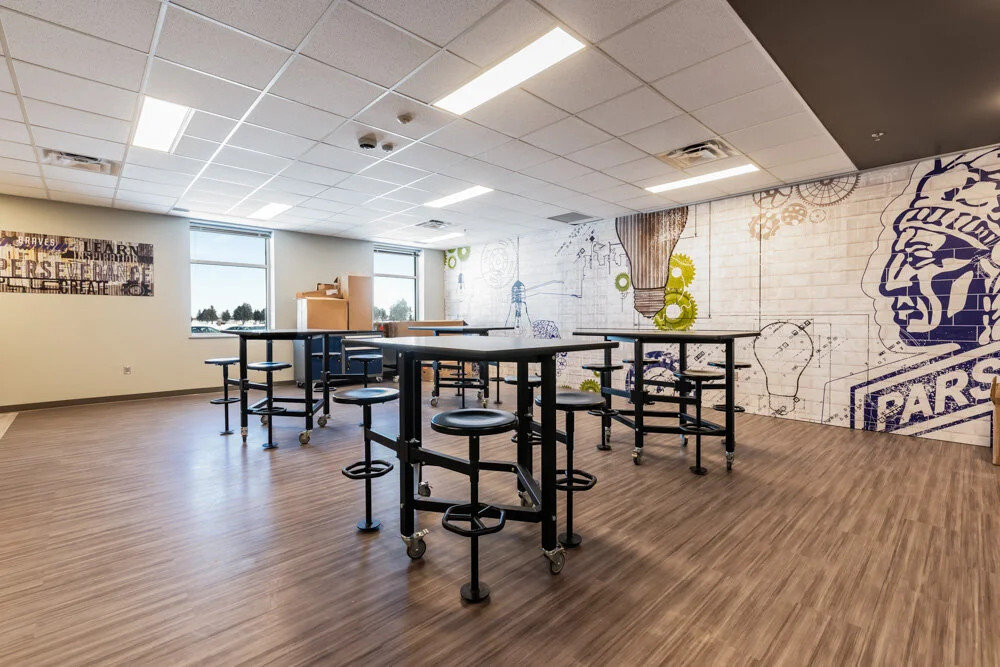 Student collaboration room with high-top tables and a Parshall Braves mascot wall graphic