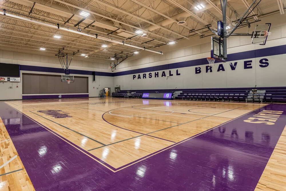 Gymnasium with purple and gold court markings and Parshall Braves branding