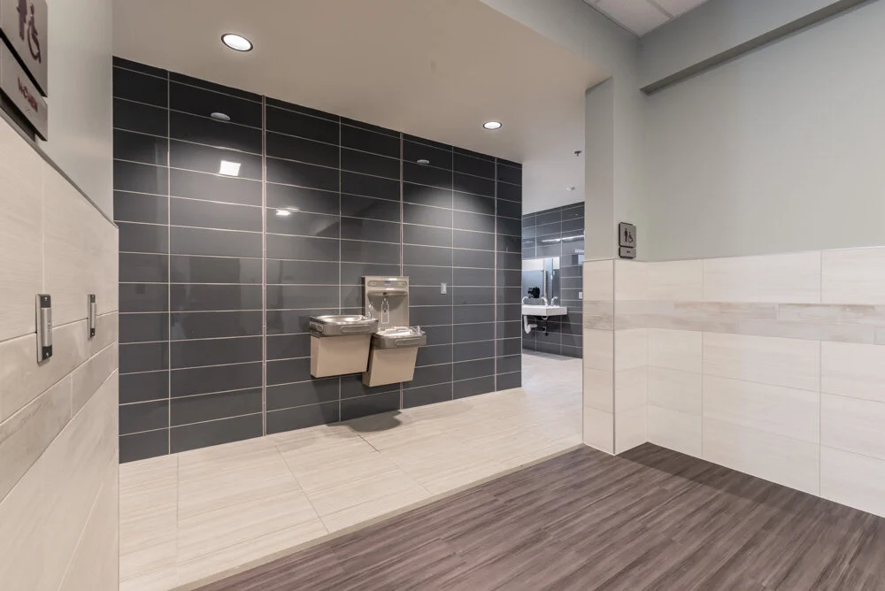 Restroom entry with dark gray wall tile and a drinking fountain