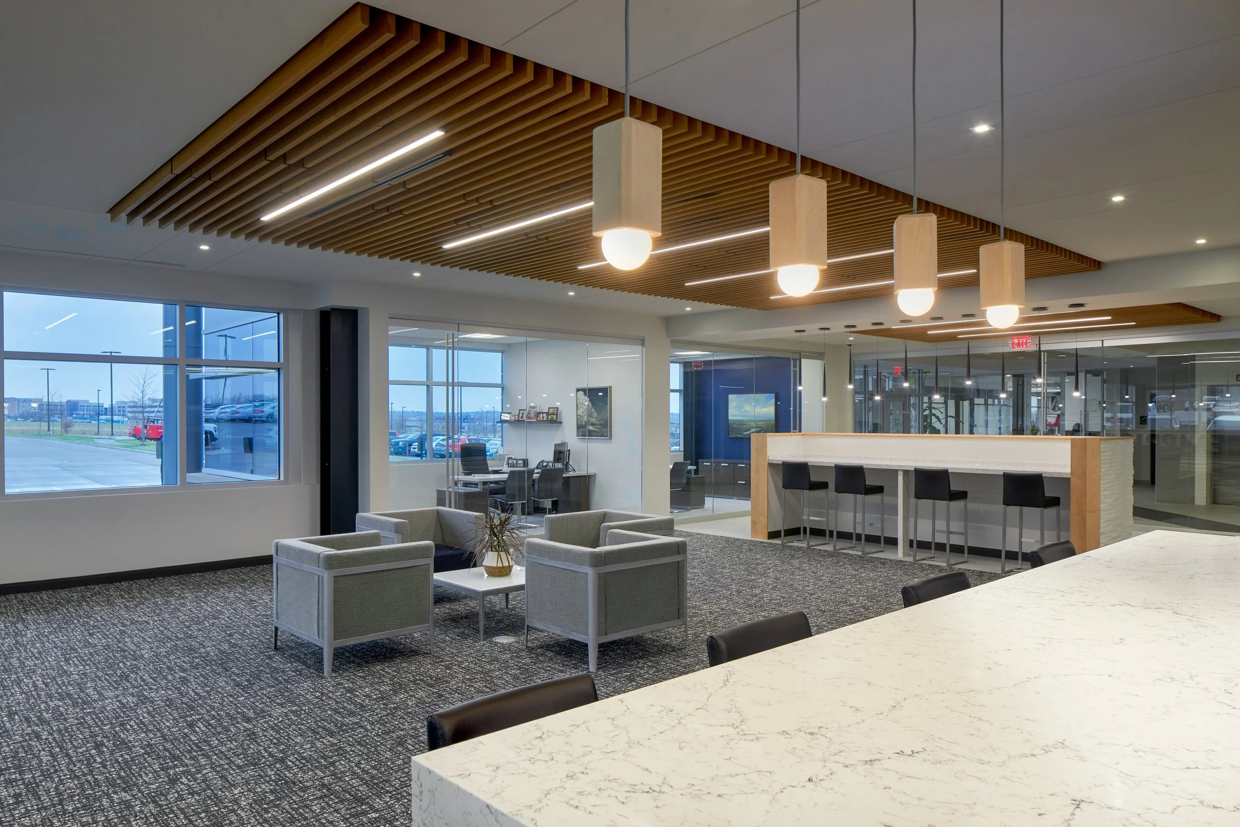 Lobby with a marble-top counter, pendant lights and lounge seating