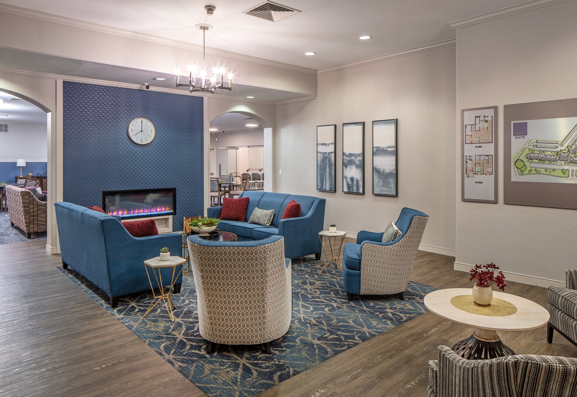 Lounge seating with blue armchairs, a fireplace and framed artwork