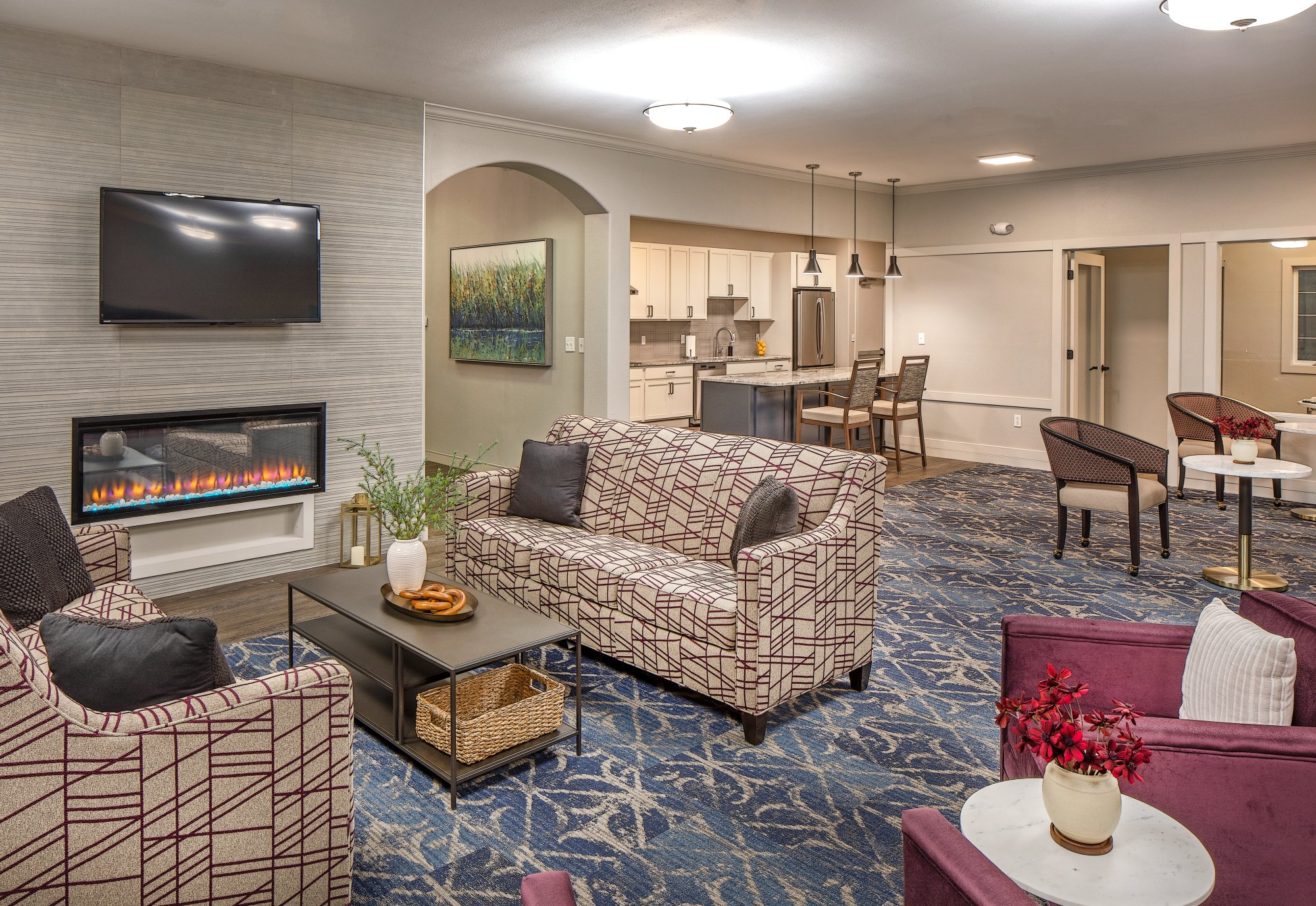 Lounge with a linear fireplace, wall-mounted TV and patterned sofas