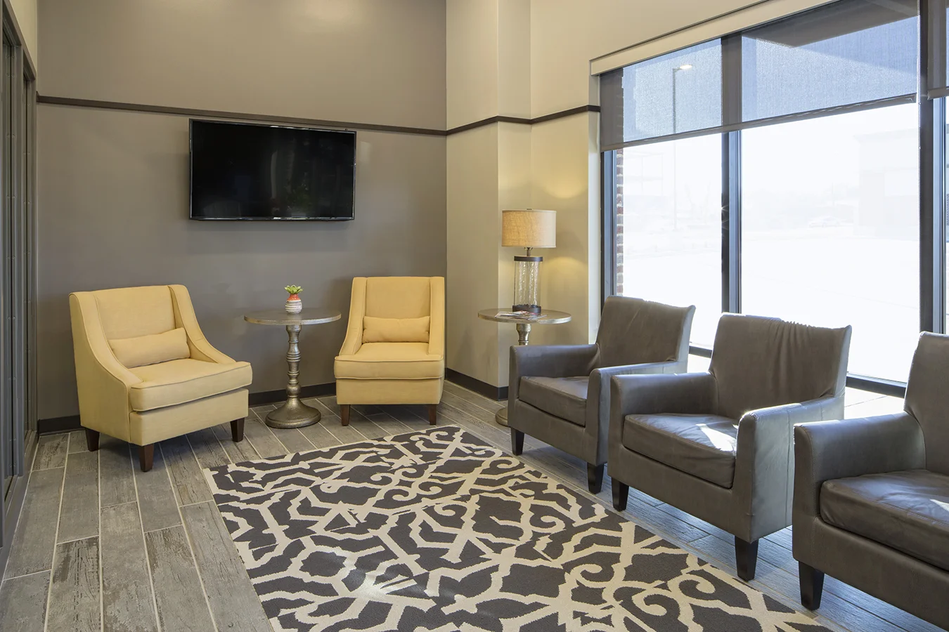 Waiting area with cream and brown armchairs and patterned rug