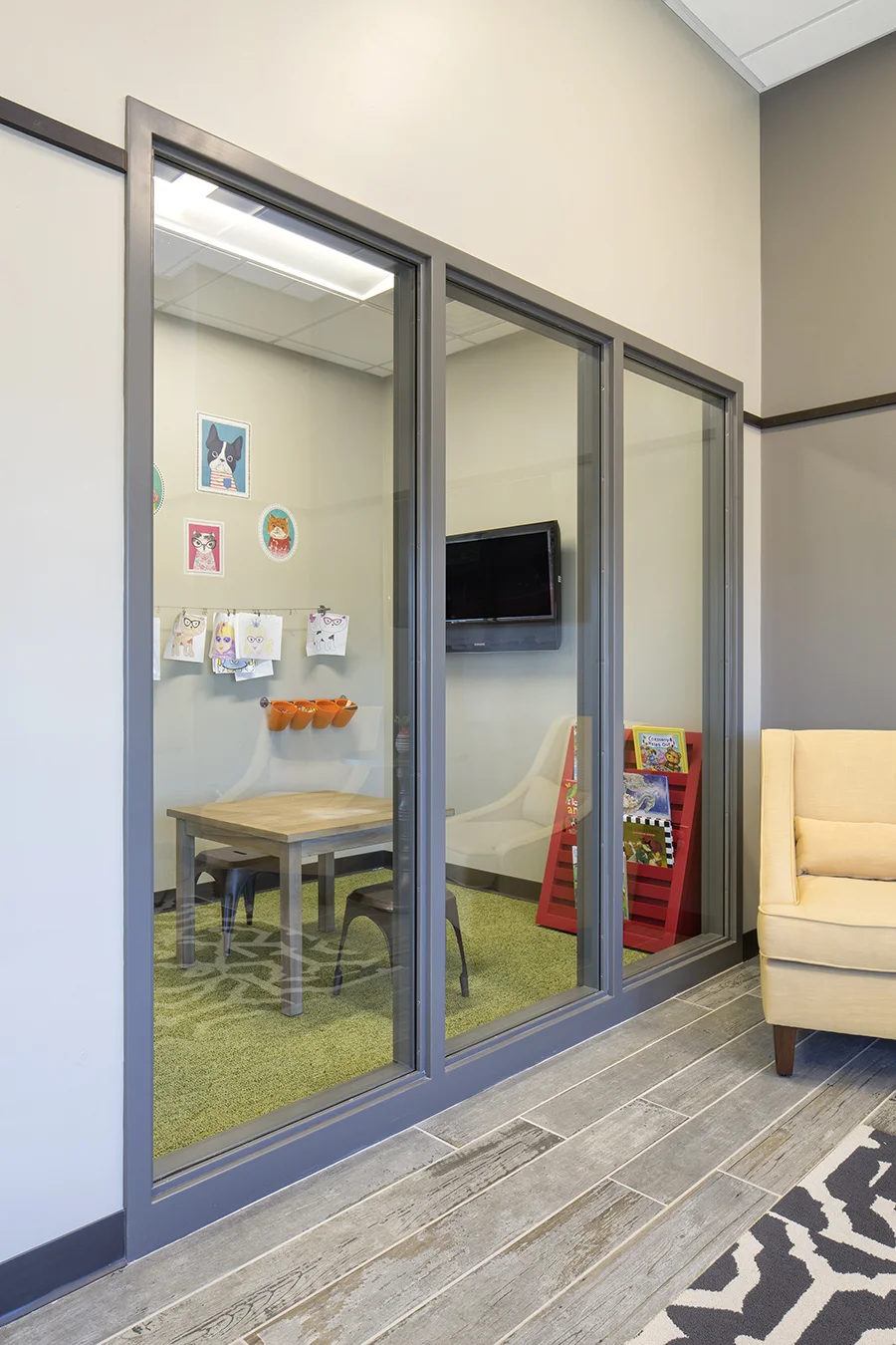 Glass-walled kids play room off the optical showroom