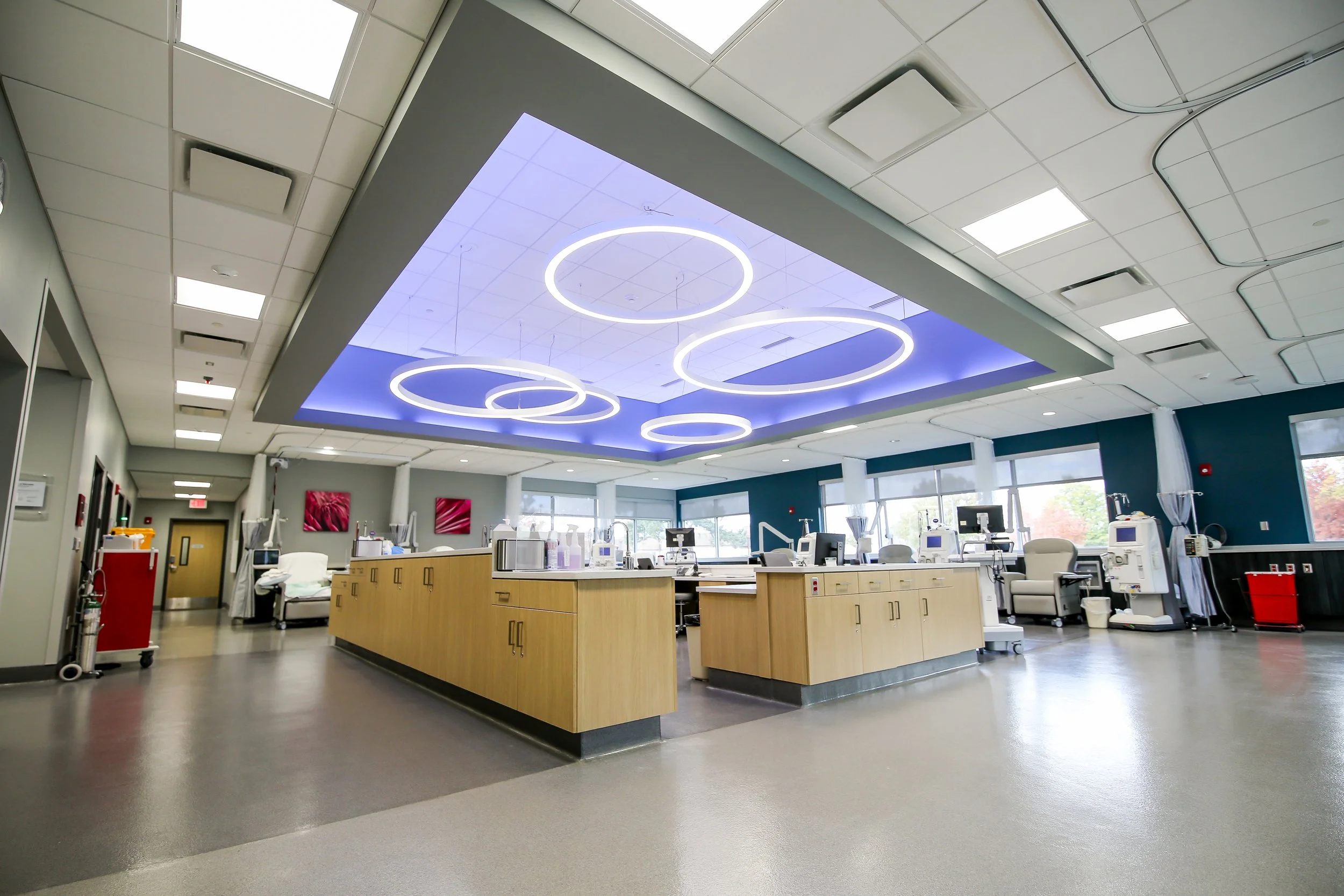 Dialysis treatment floor with a nurses station and a lit ceiling feature with ring lights