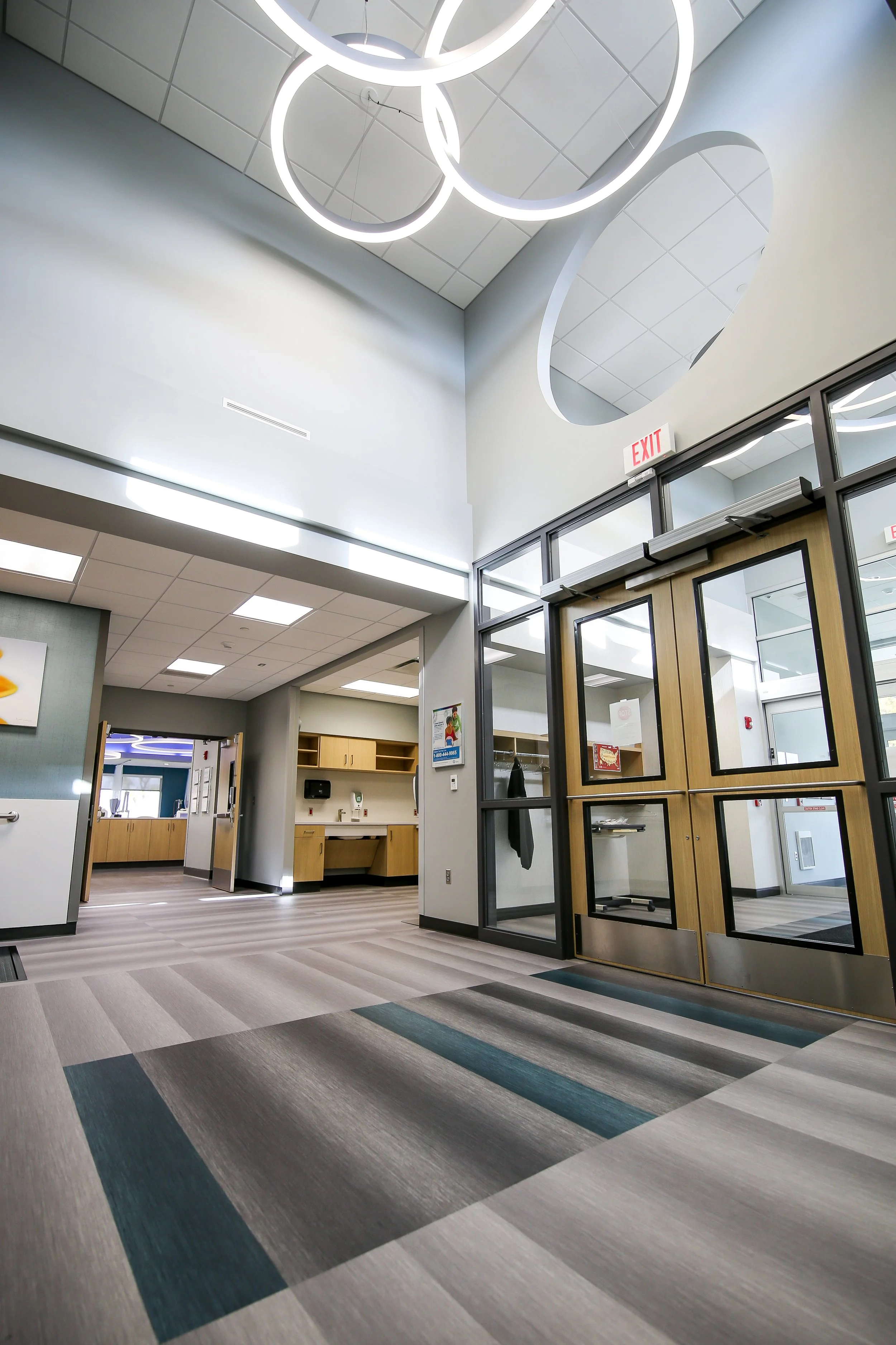 Entry vestibule with ring pendant lights and striped carpet