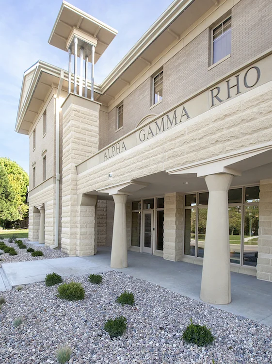 Stone entry portico of the Alpha Gamma Rho house with the chapter name carved above