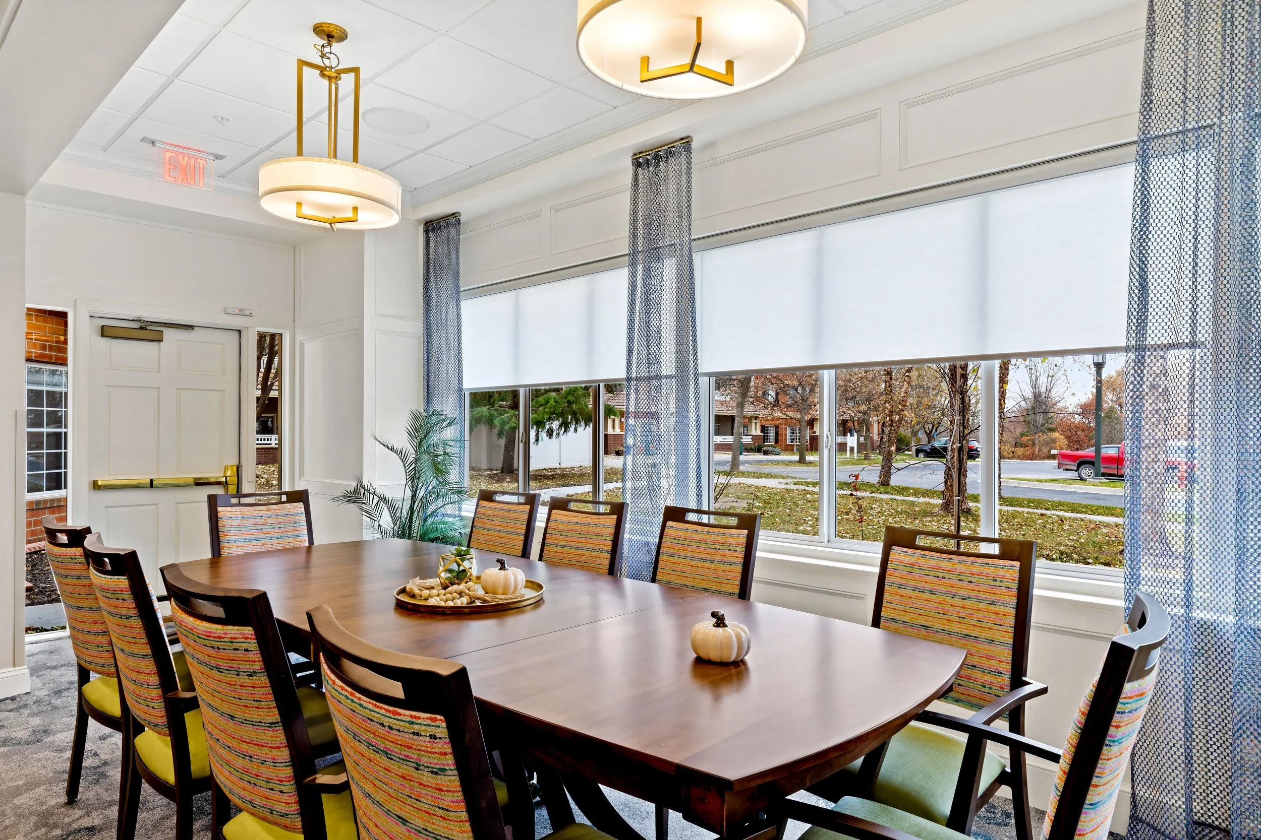 Private dining room with a long wood table, patterned chairs and large windows