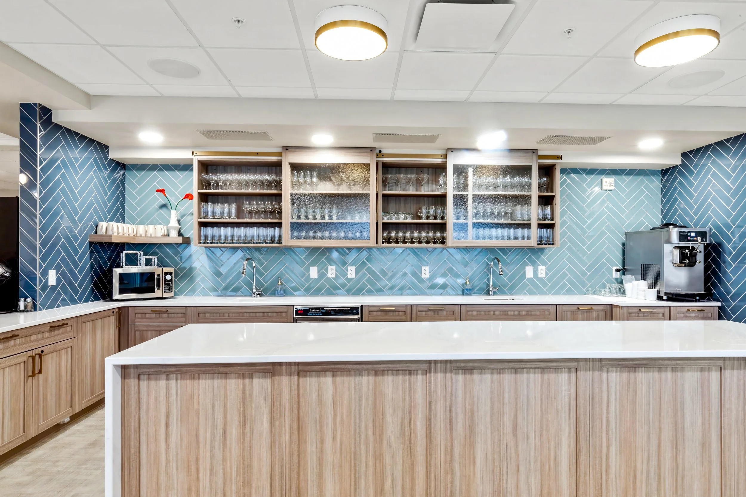 Coffee bar with blue herringbone tile, open shelves and a white quartz counter