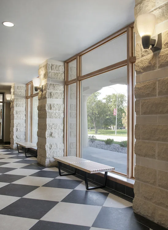 Window bench in a limestone hallway with a checkered floor