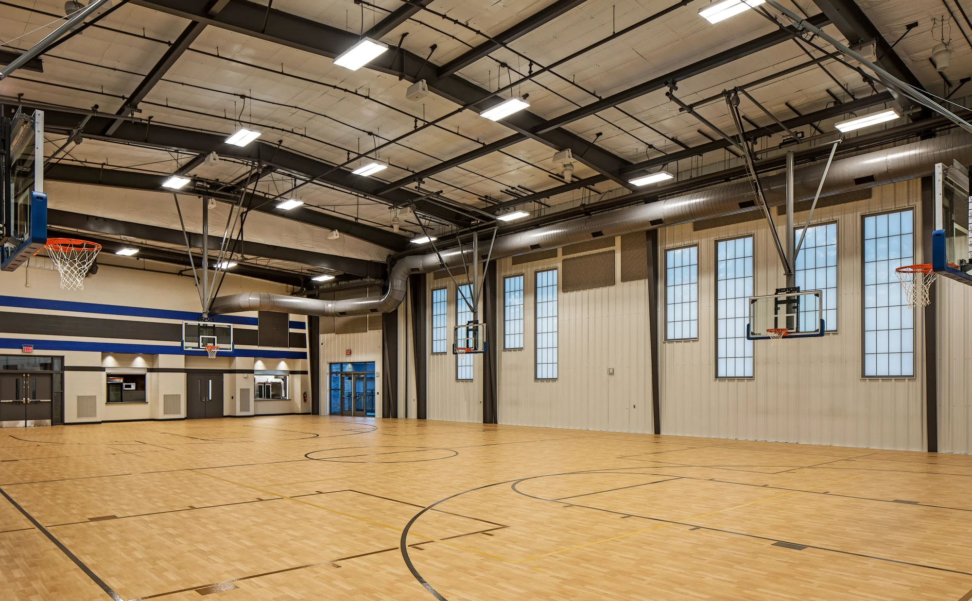 Community gymnasium with a wood basketball court and blue accents