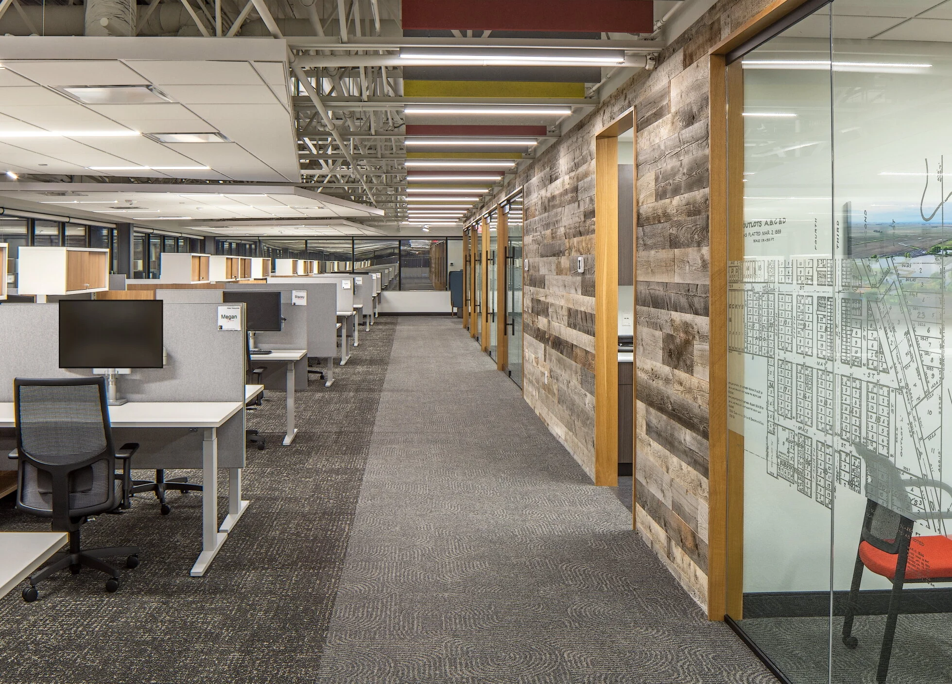 Open office with sit-stand workstations, reclaimed wood walls and a map wall graphic