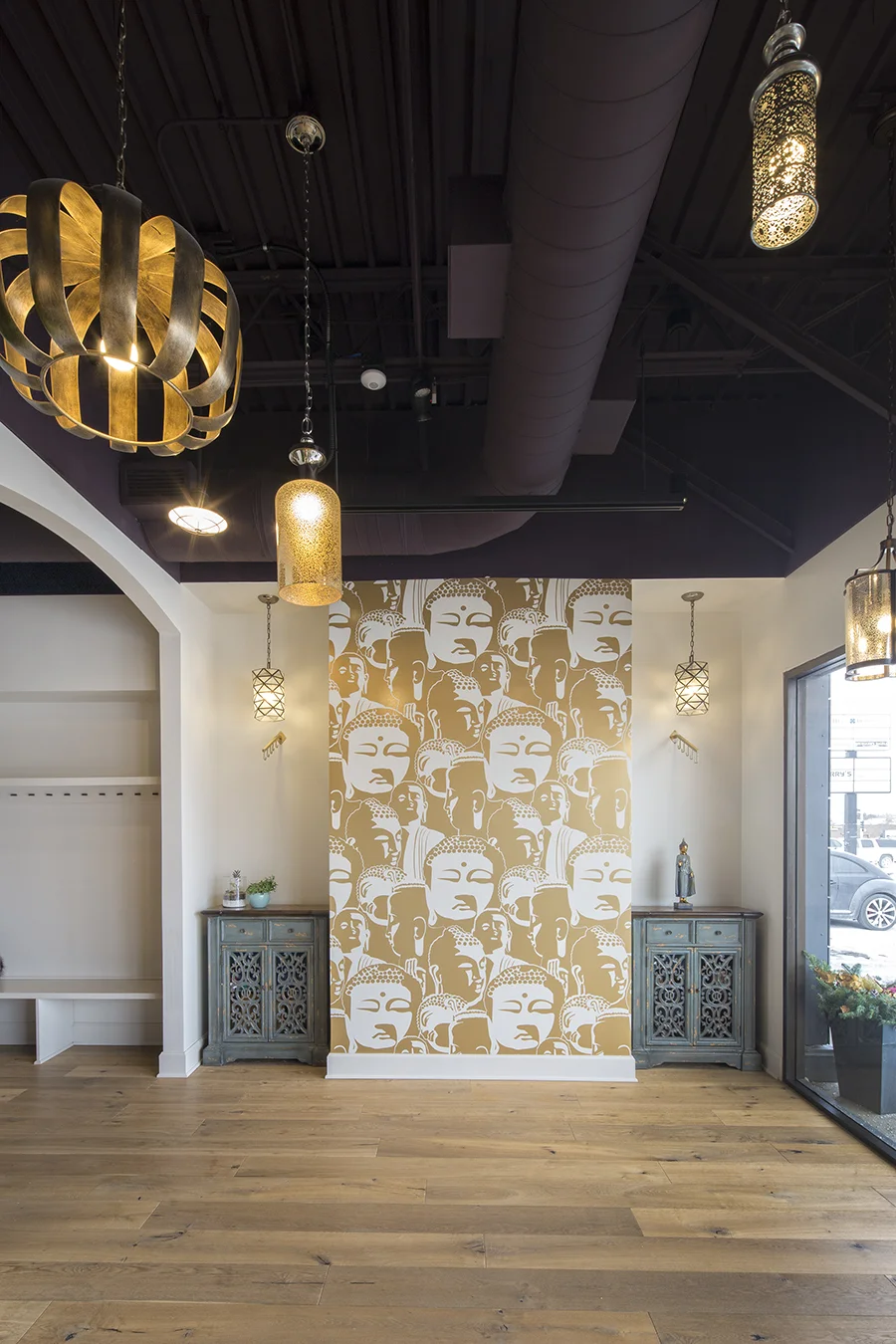 Entry at Lighthouse Yoga in Omaha with gold pendant lights and a patterned accent wall