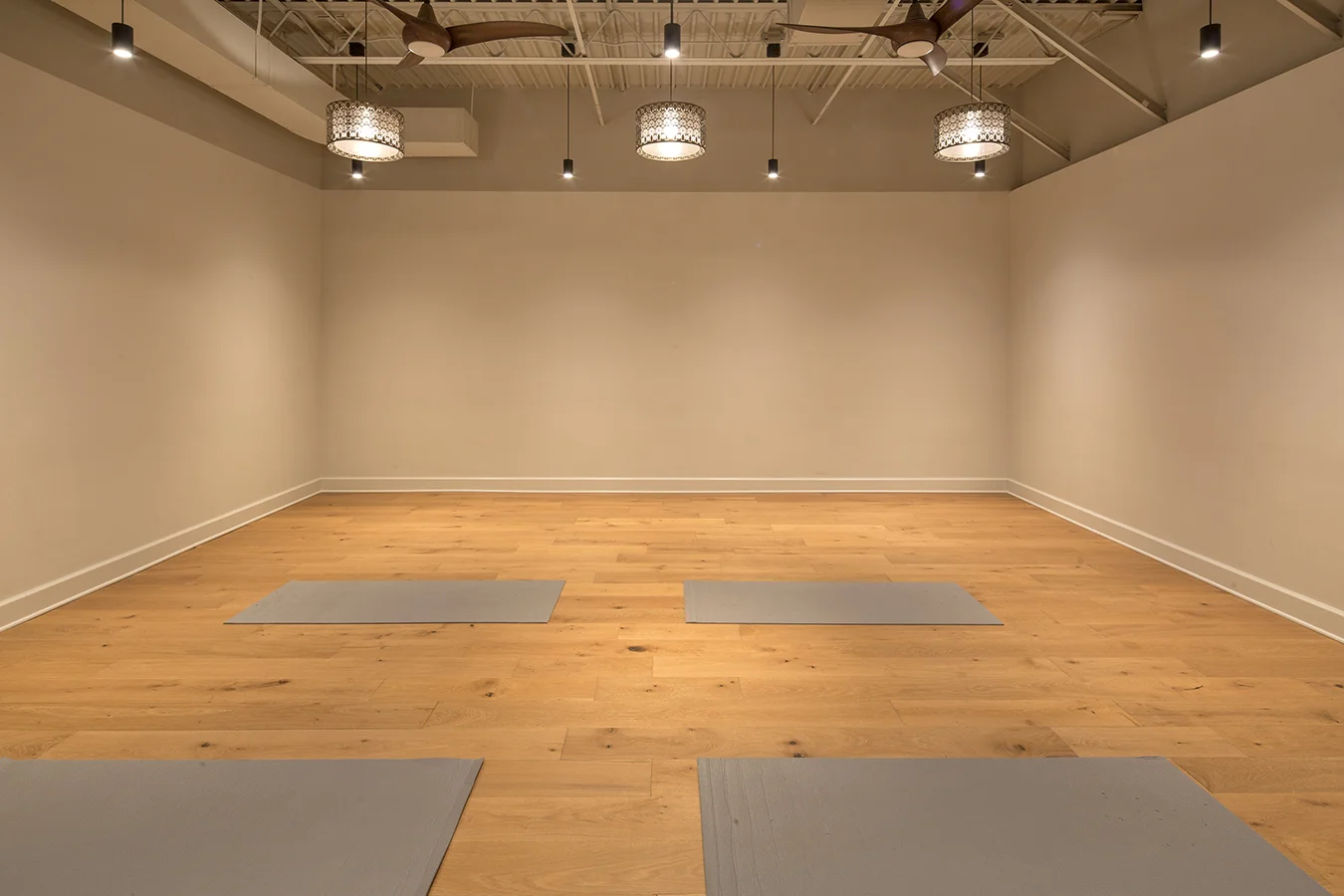 Yoga practice room with wood floors, mats and a dark ceiling