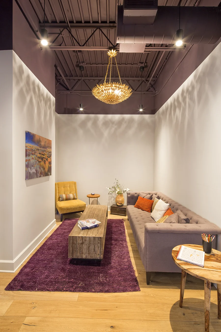 Lounge nook with a sofa, purple rug and wood floors