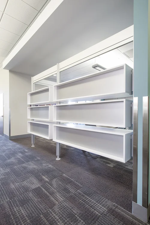 White open shelving unit against a blue wall