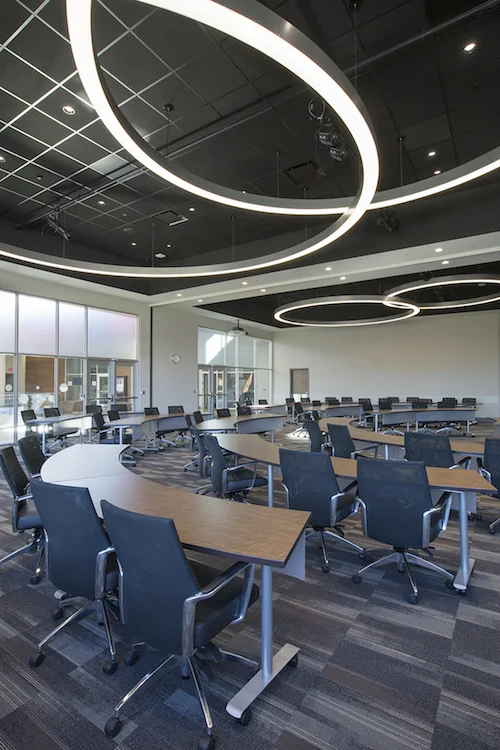 Large meeting room with ring light fixtures and rows of training tables