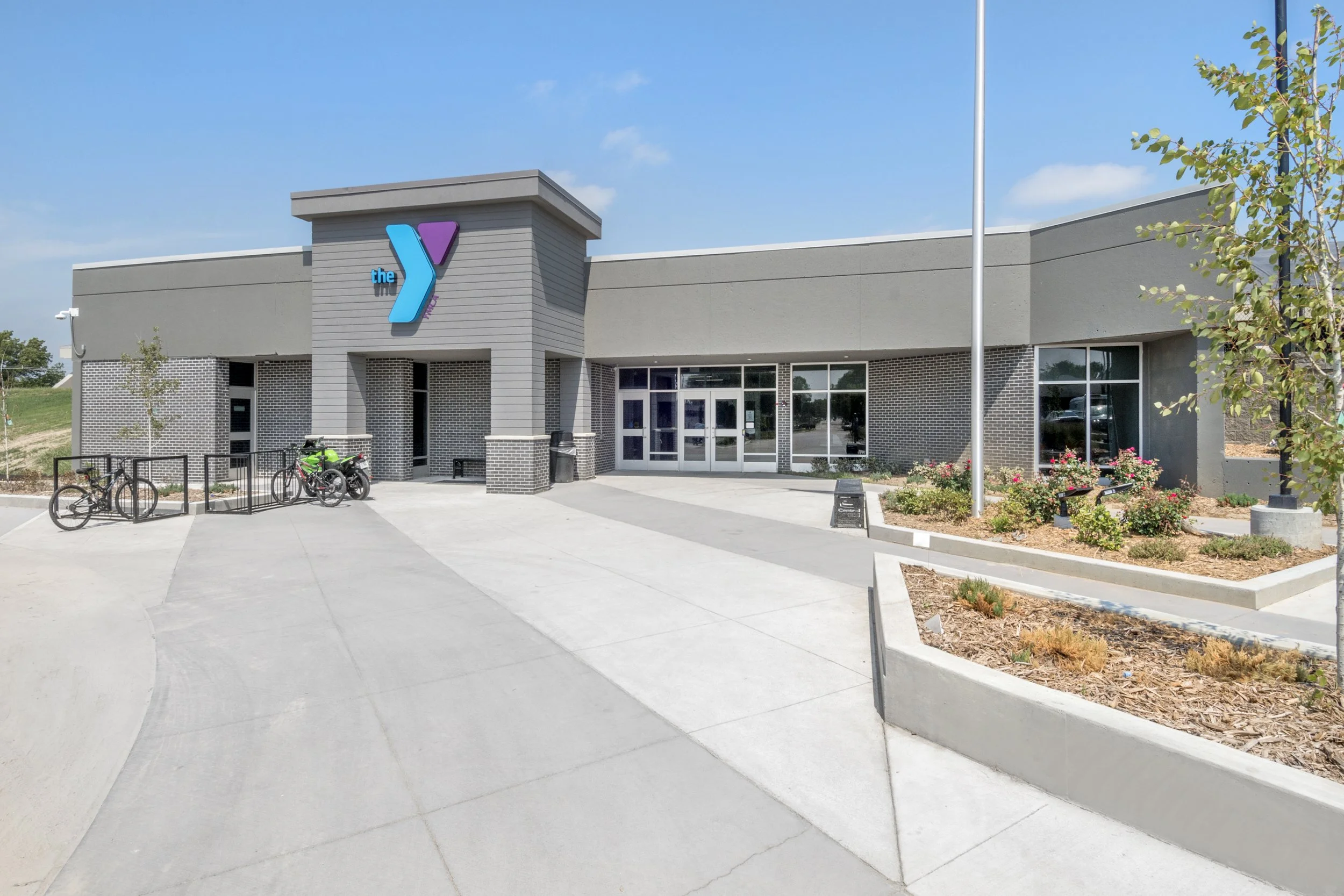 Exterior entrance of the Hastings YMCA with the Y logo and landscaped plaza