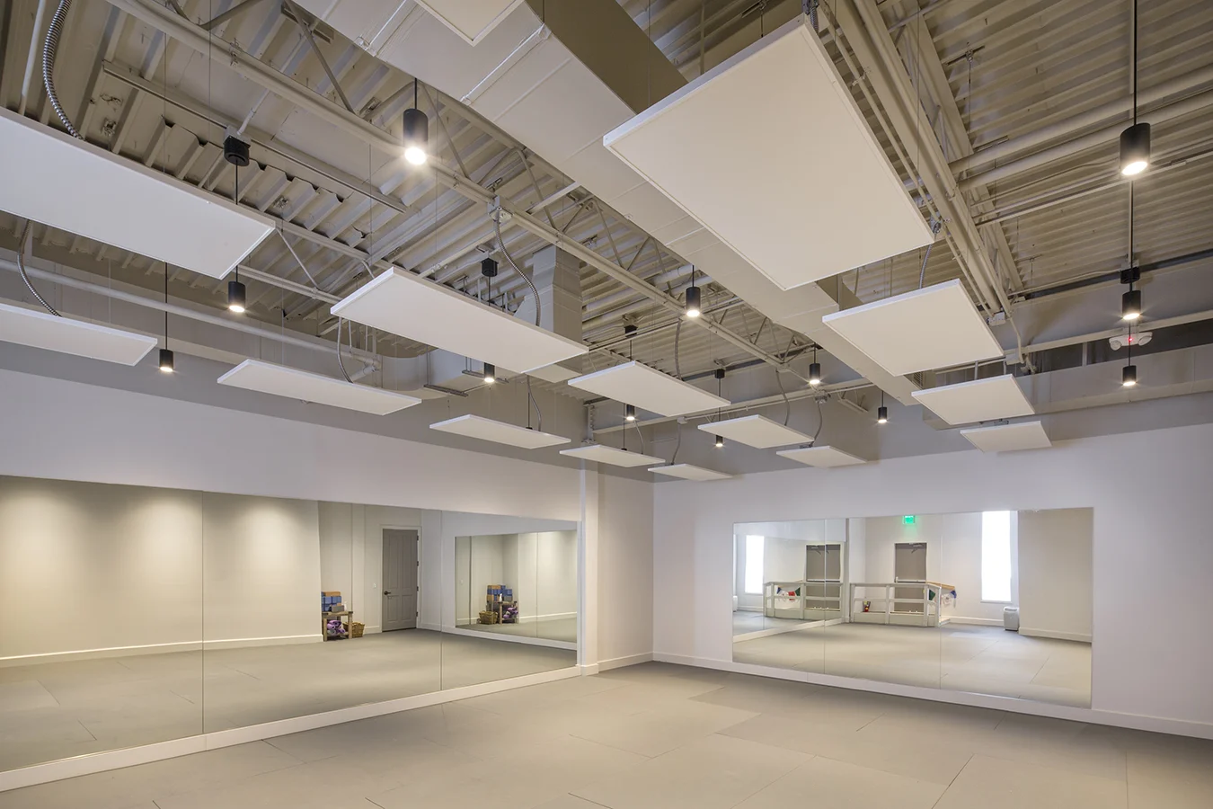 Studio with angled white acoustic ceiling panels and a mirrored wall