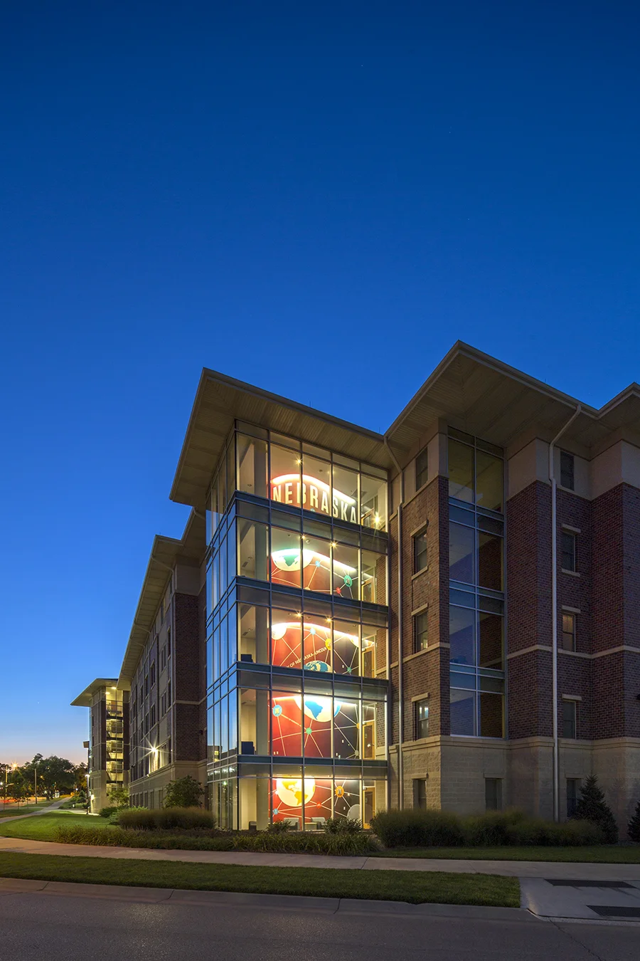 Eastside Suites residence hall exterior with brick and glass at dusk