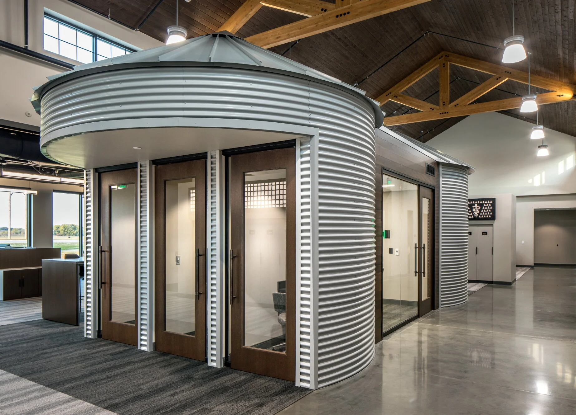 Grain-bin inspired meeting rooms clad in corrugated metal under a timber roof