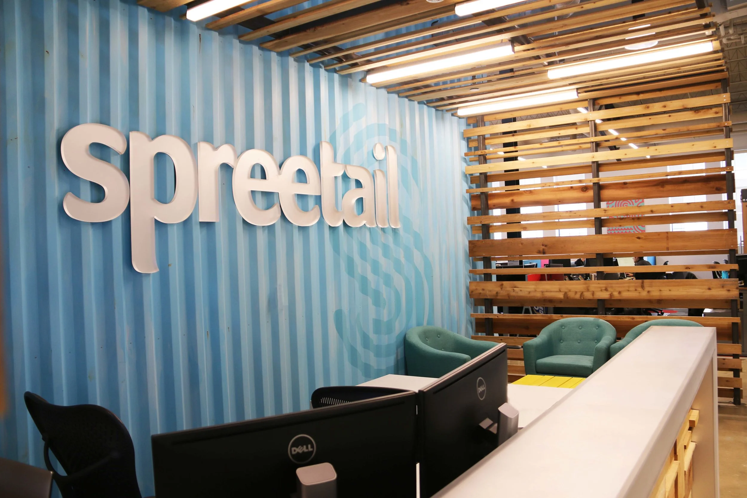Spreetail reception in Lincoln with a blue corrugated logo wall and reclaimed wood slats