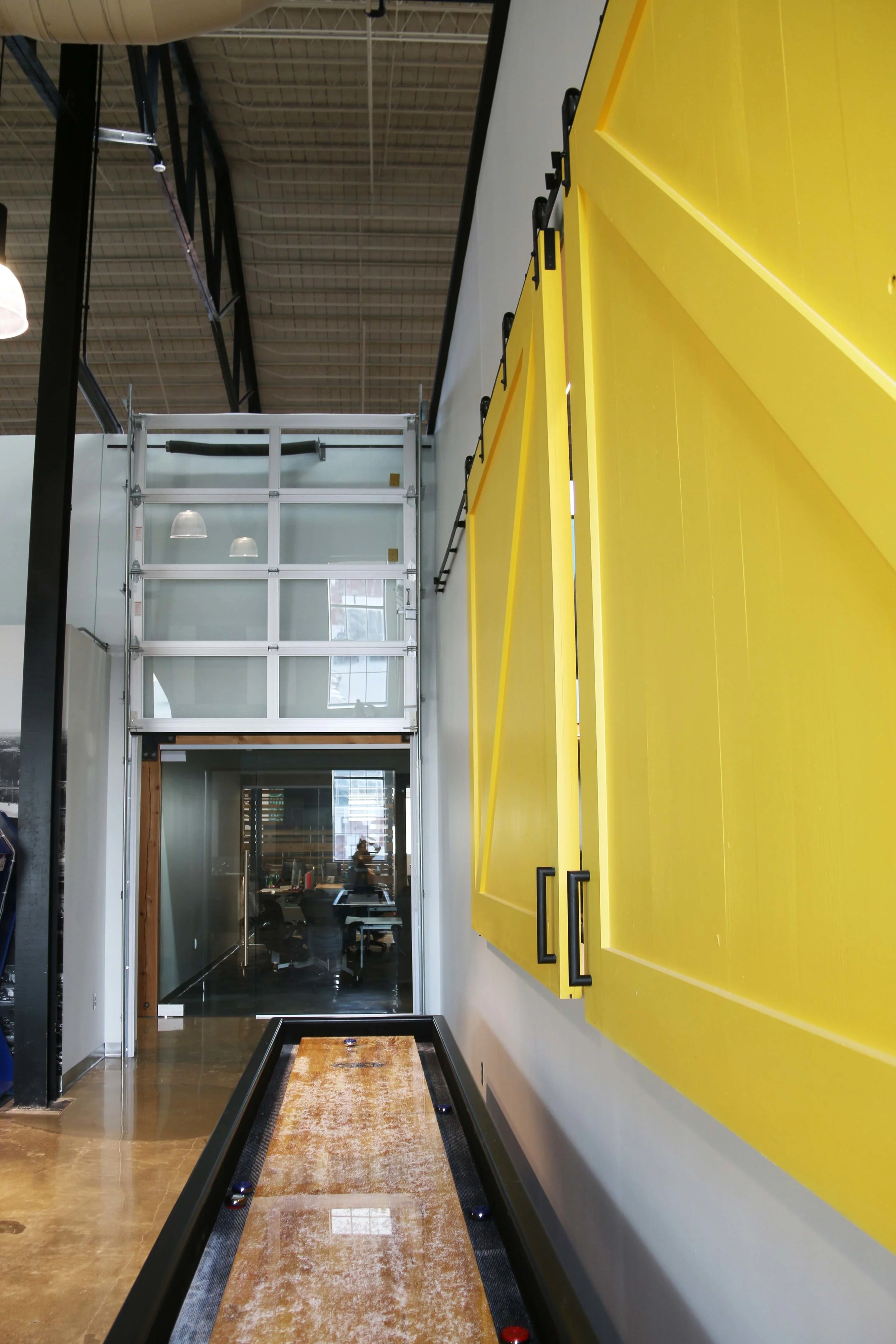 Corridor with a yellow accent wall and polished concrete floor