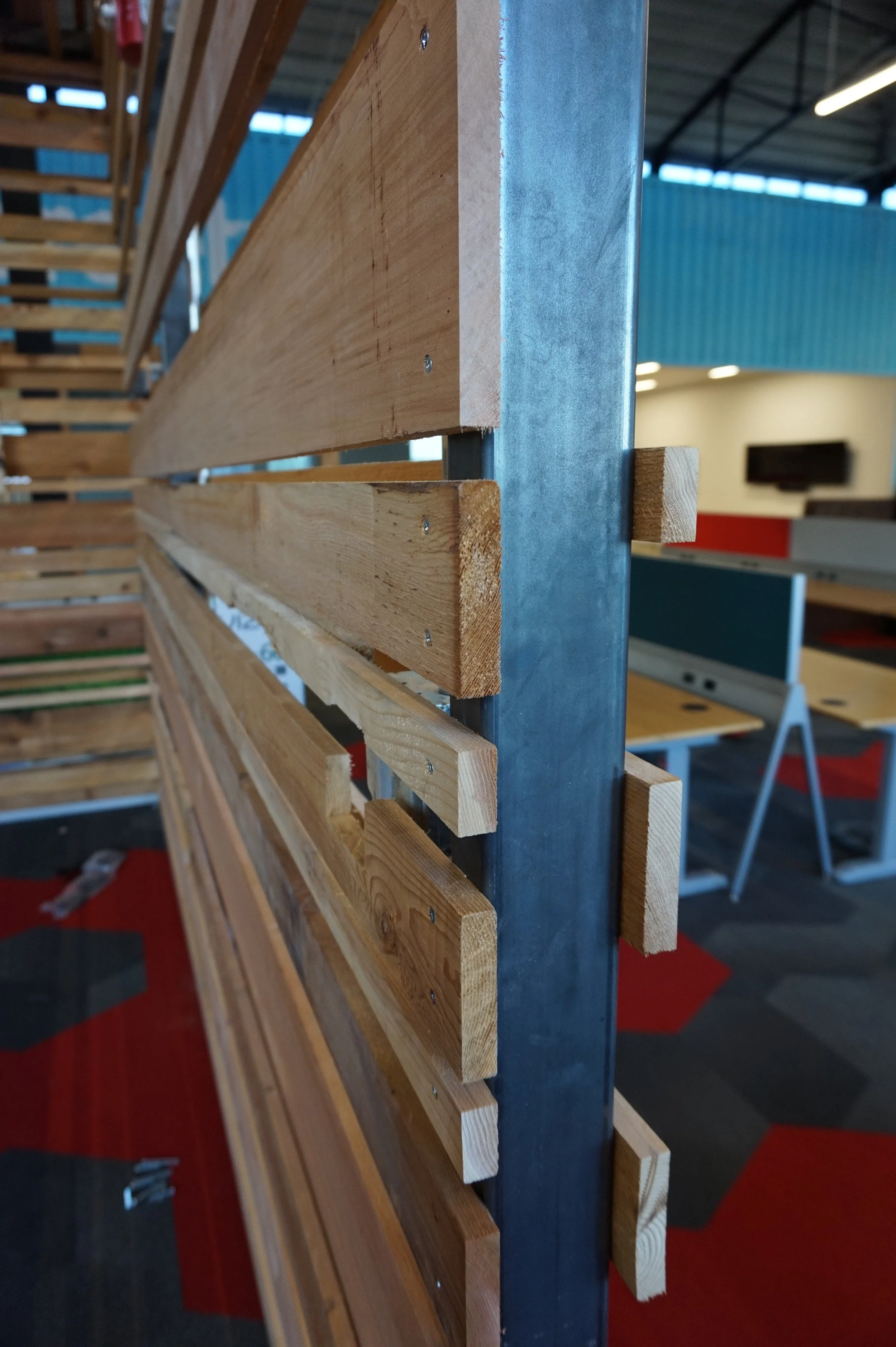 Reclaimed wood partition with red carpet tile beyond