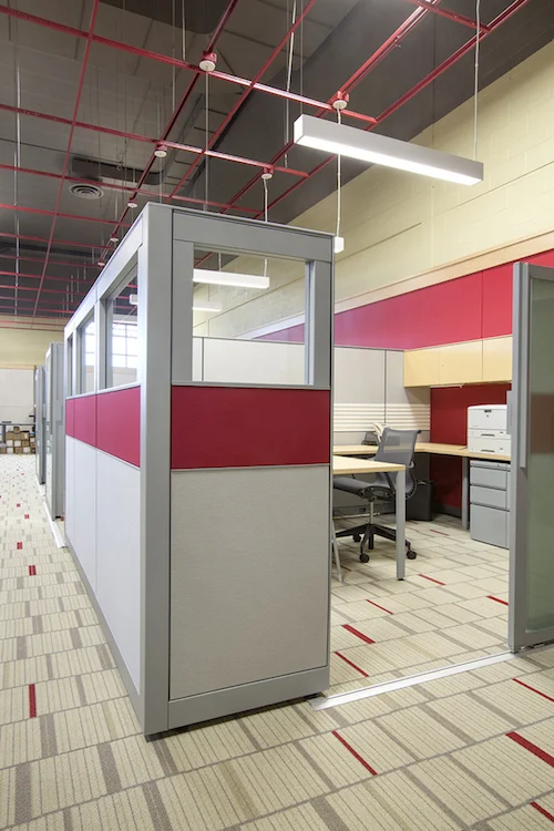 Faculty office workstations with red and gray panels and exposed ceiling