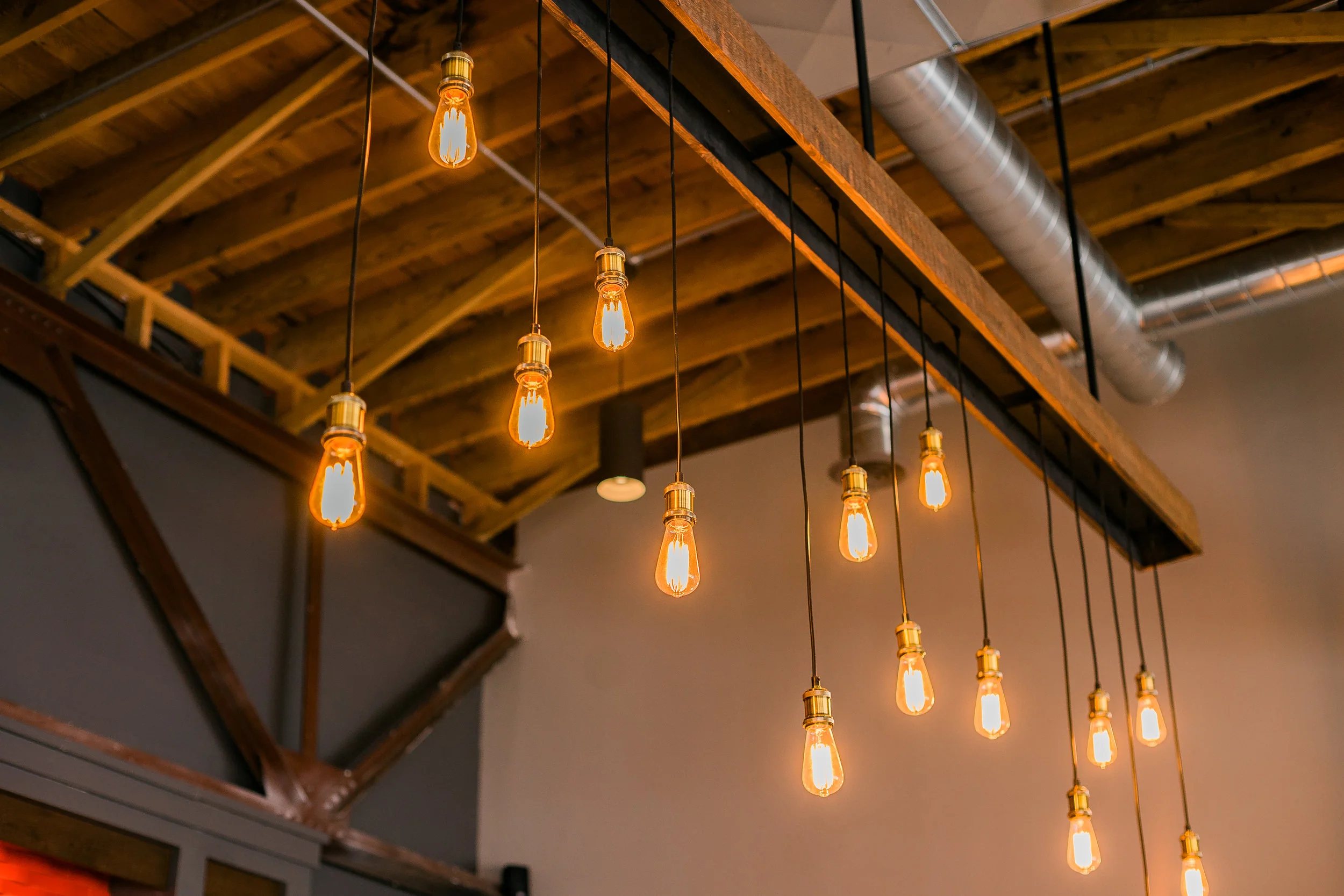 Cluster of Edison bulb pendants hanging from exposed wood beams