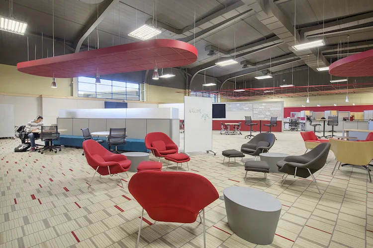 Lounge with red womb chairs, gray sofas and red ceiling clouds