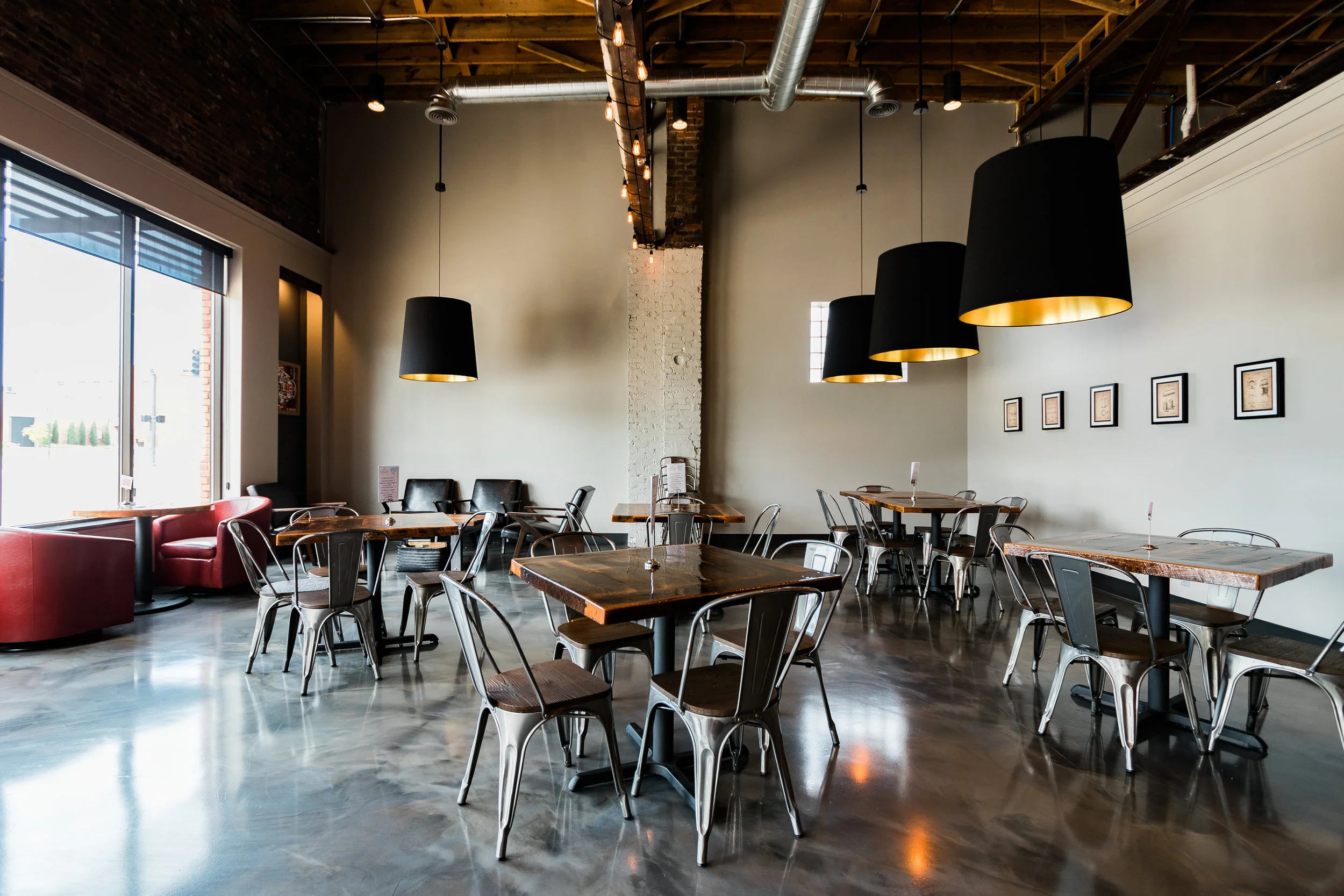 Taproom with polished concrete floors, metal chairs and large windows