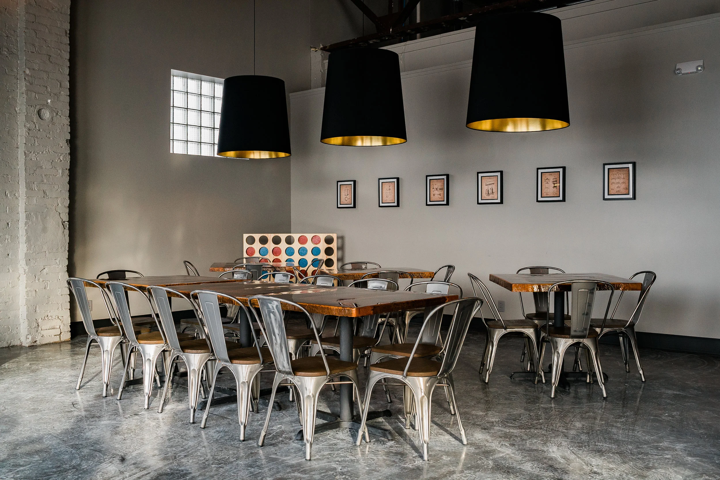 Taproom at Code Beer Co. in Lincoln with metal chairs, wood tables and black cone pendants