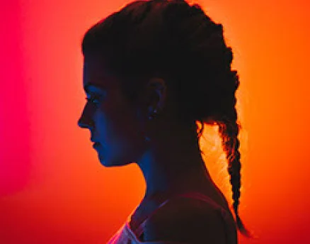 Silhouette side profile of a creative professional under warm studio lighting
