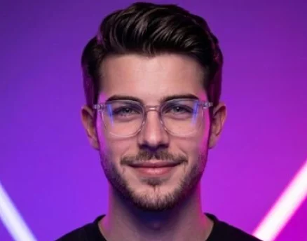 Portrait of a smiling creative agency team member with glasses under neon studio lighting