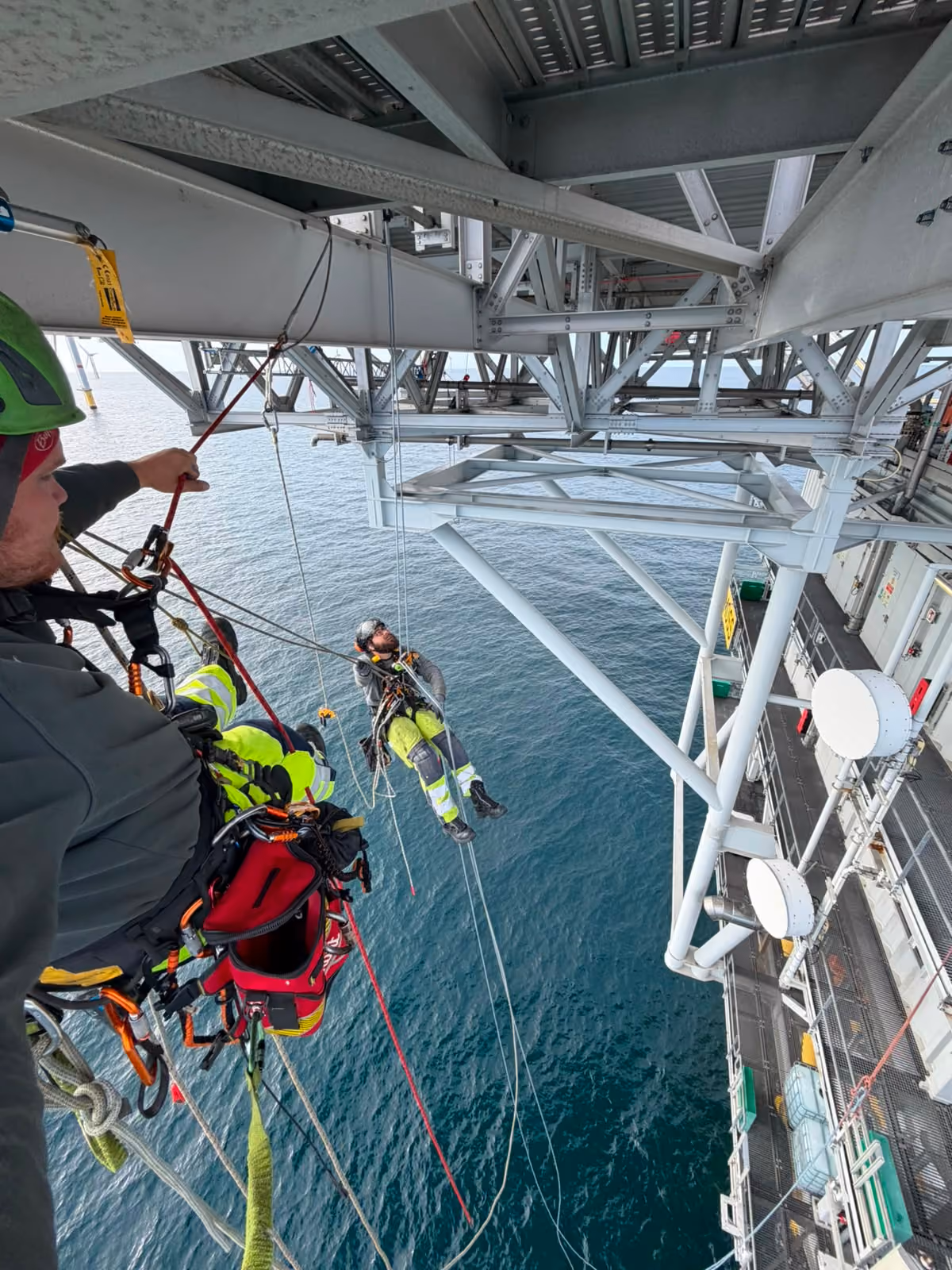 Seilzugangstechniker von mh² offshore im Seil unter einer Offshore-Plattform