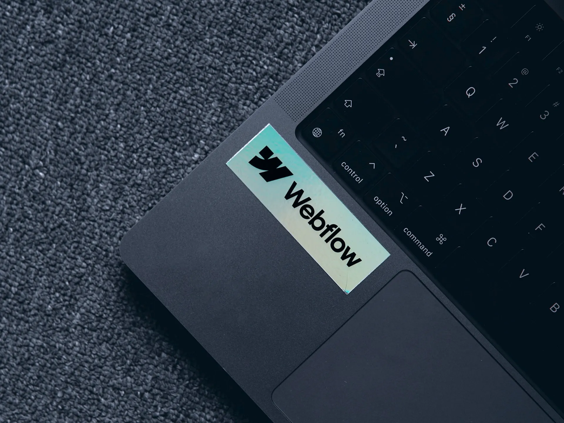 Webflow agency werkplek met laptop en Webflow sticker voor high-end webdesign en development