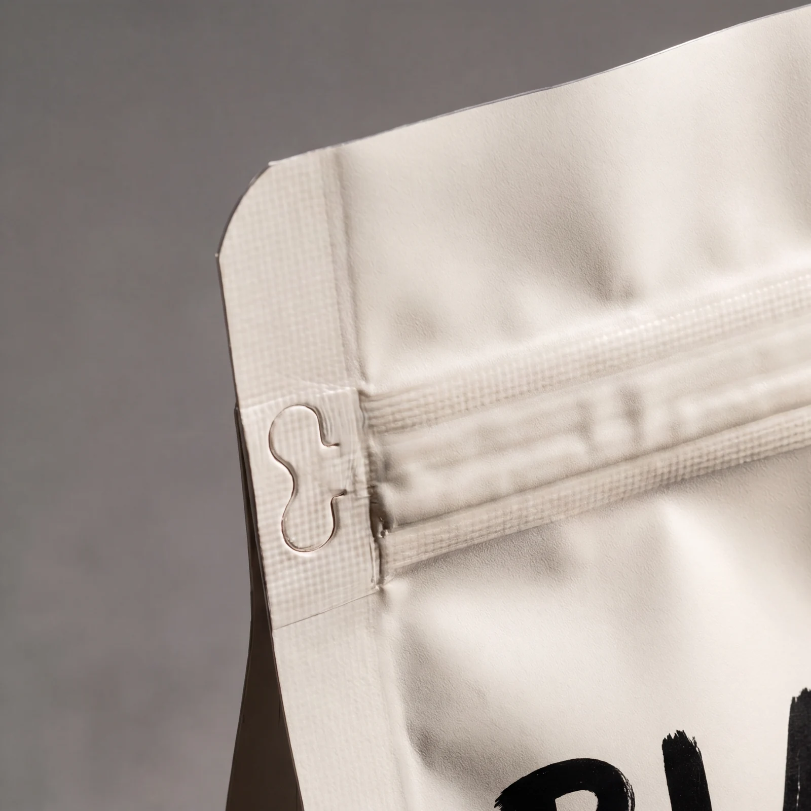 Close-up of beige packaging corner with a tear notch for easy opening.