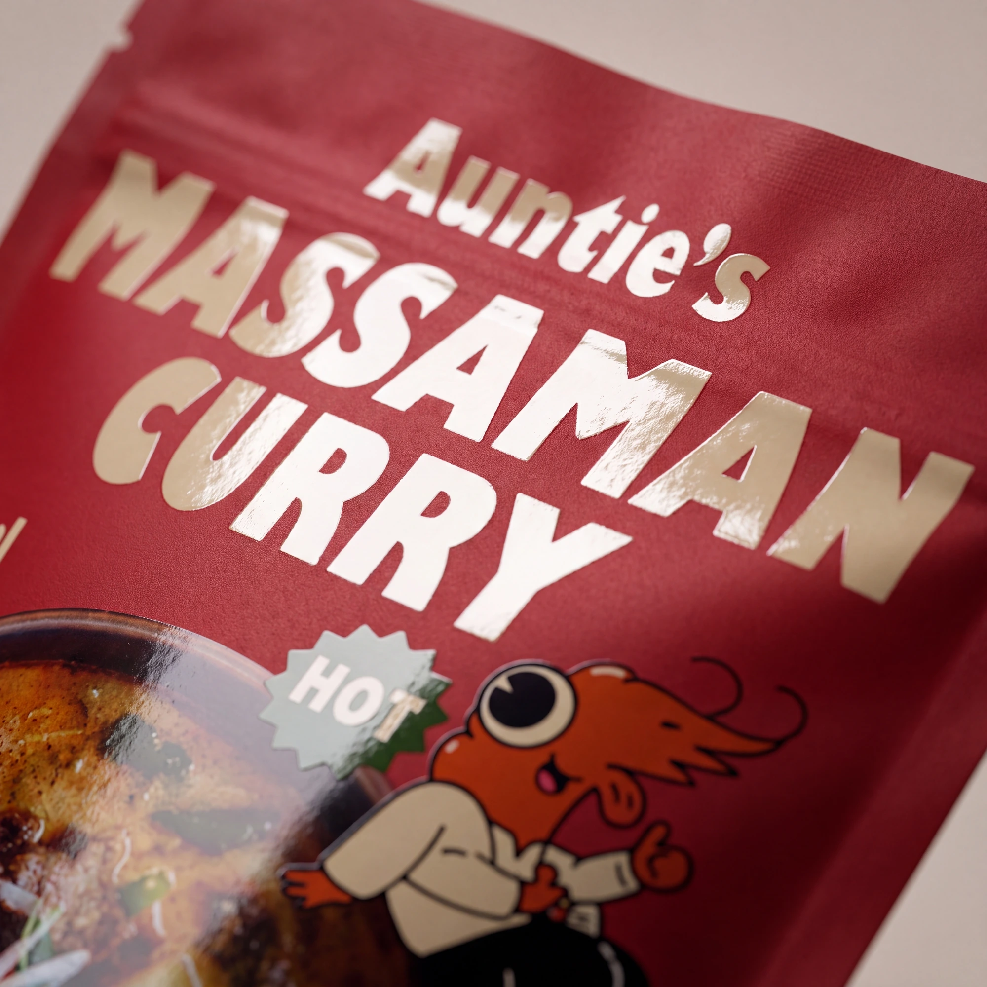 Red package of Auntie's Massaman Curry with a cartoon character and a 'HOT' label.