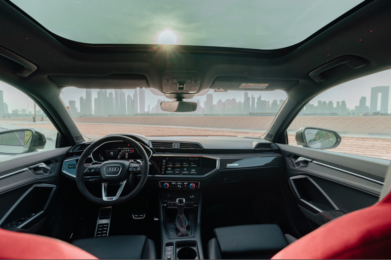 Interior of an Audi car with city skyline view through windshield