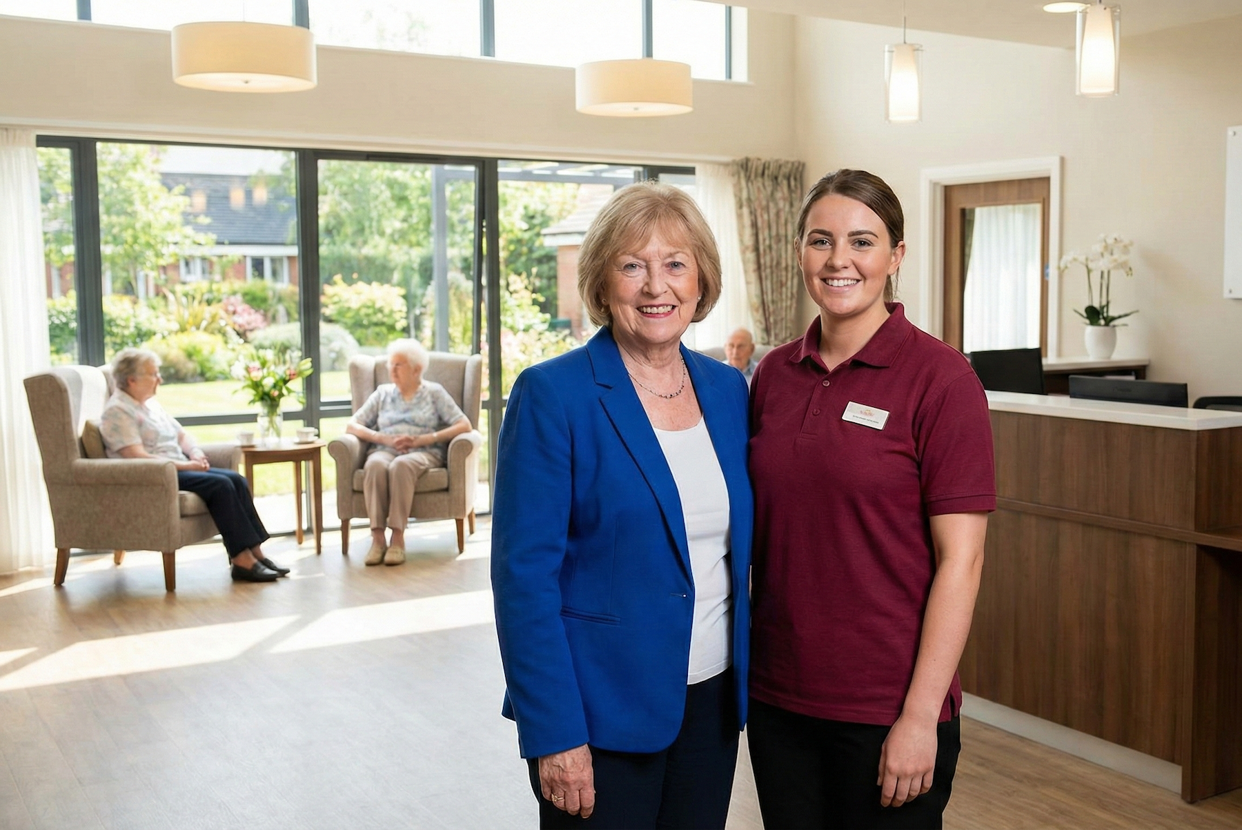A resident and a member of staff in the lounge of a residential care home