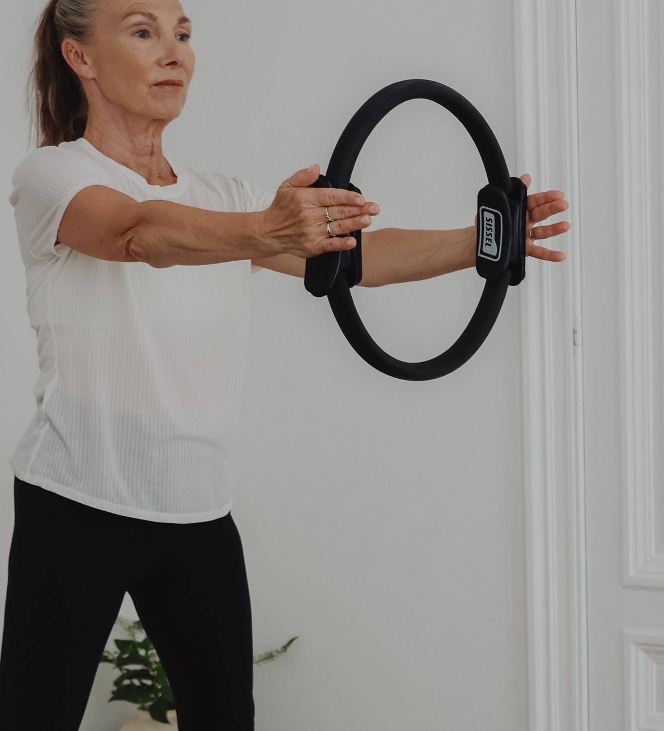 Vrouw in de menopauze traint met een pilatesring op de reformer bij Studio Bij 't Vuur in Antwerpen.