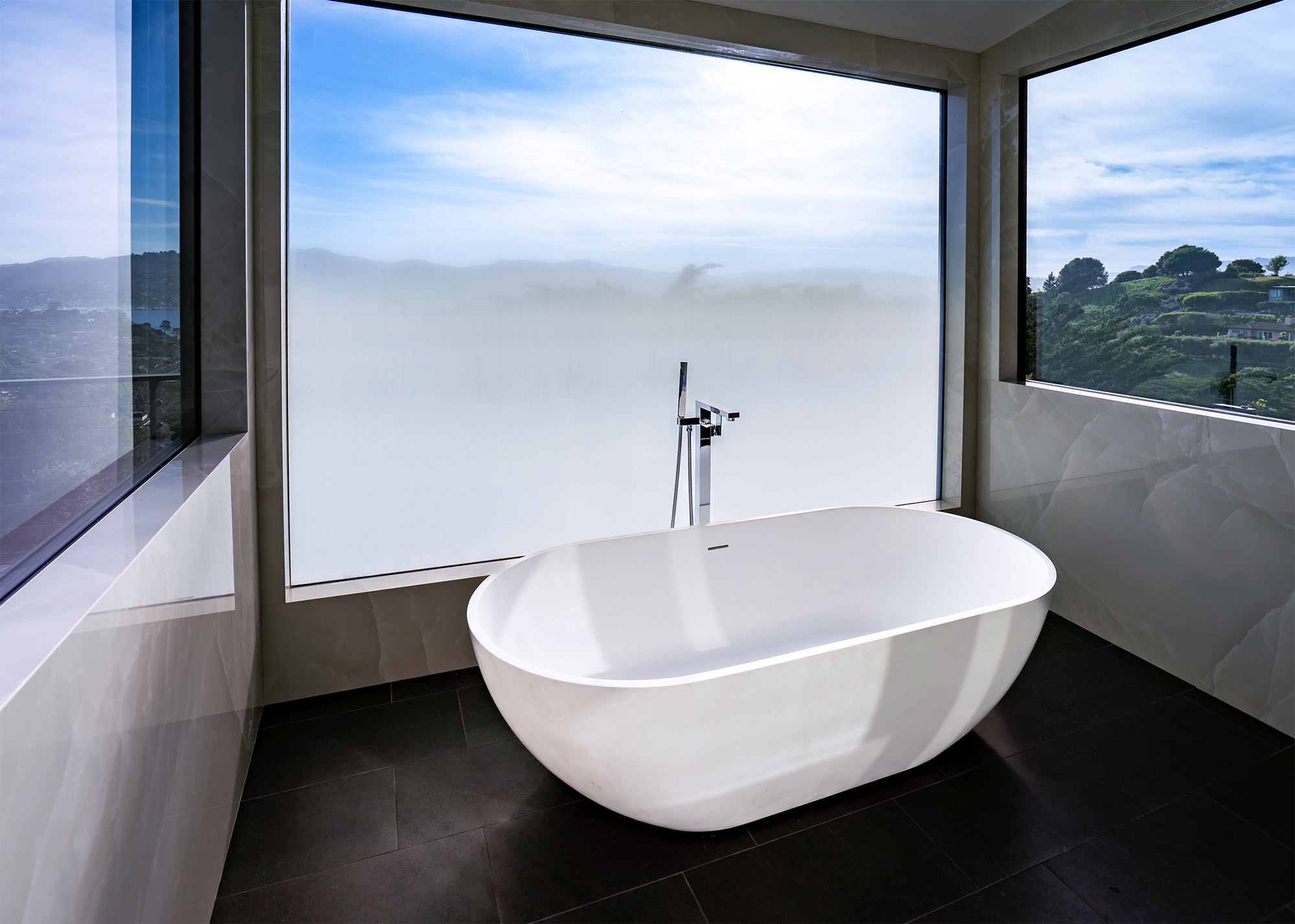 Freestanding soaking tub framed by bay views in a Tiburon bathroom remodel