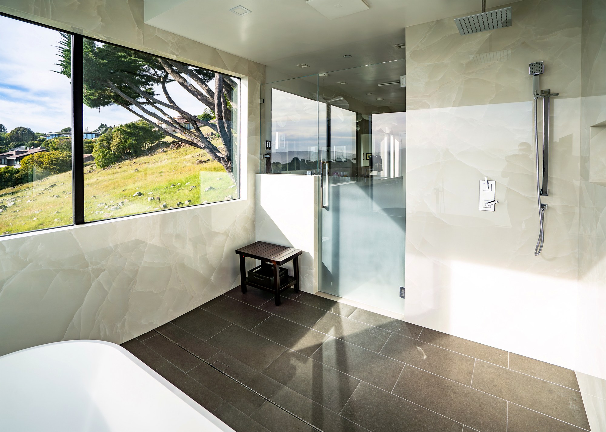 Curbless glass shower and stone tile in a Tiburon primary bathroom remodel