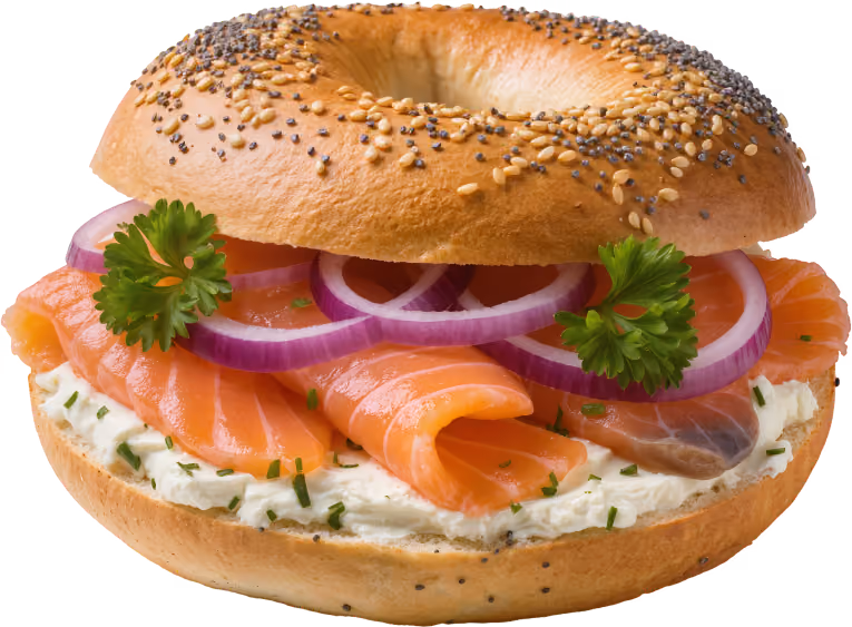 Bagel with cream cheese, smoked salmon, red onion rings, and parsley garnish.