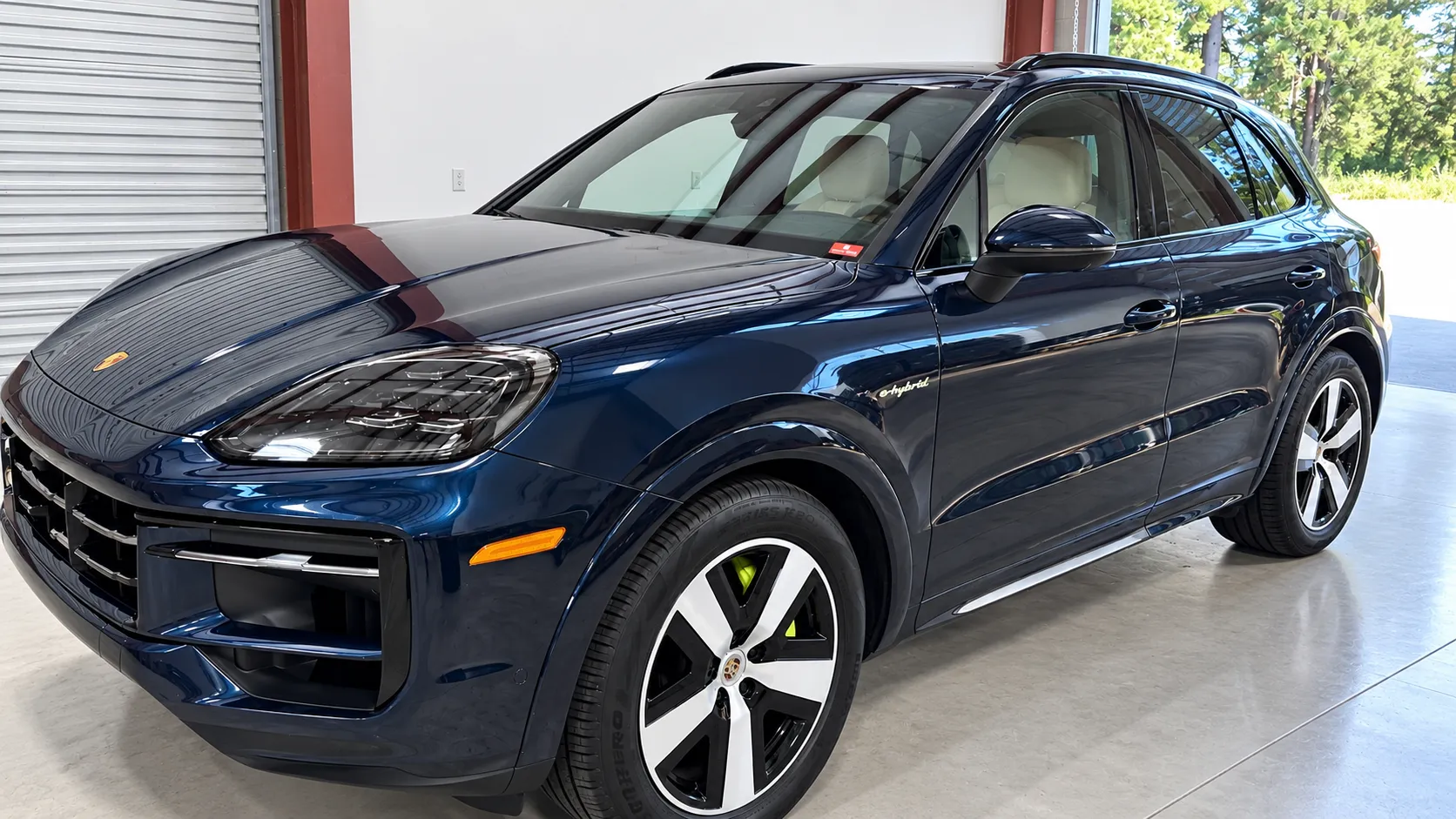 Blue Porsche SUV viewed from the front and side inside the Truckee shop.