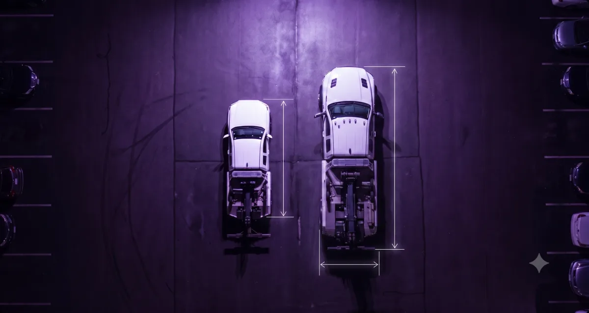 Overhead view comparing a compact NovaTow unit beside a full-size tow truck in a parking bay, with measurement guides