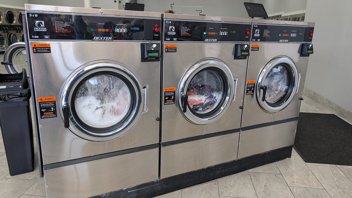 Three Dexter commercial washers running a wash cycle